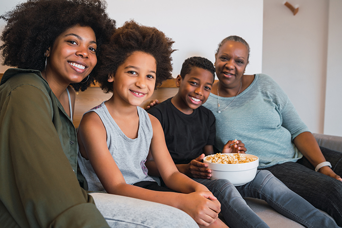 Uma família reunida sentada em um sofá da sala